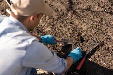 Sebze bahçesindeki çiftçi, bahçe aletleri.