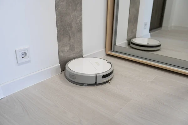 Aspiradora robótica moderna en el suelo en la sala de estar. Espacio para texto —  Fotos de Stock