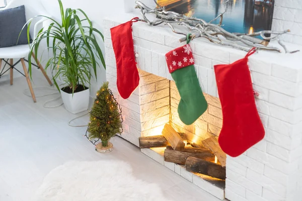 Lareira com meias de Natal no interior do quarto festivo . — Fotografia de Stock