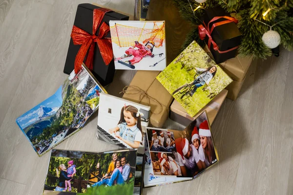 Lienzo fotográfico y libros de fotos cerca del árbol de Navidad como regalo — Foto de Stock