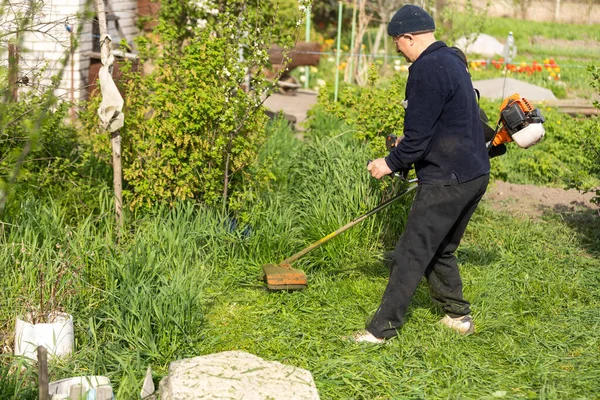 Man with lawn mower, a man mows the grass — Zdjęcie stockowe