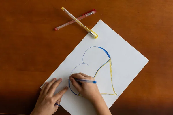 Kinderhand mit Bleistift zeichnet das Herz — Stockfoto
