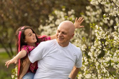 Mutlu torun yeşil çimlerde gülümseyen büyükbabasına sarılıyor.