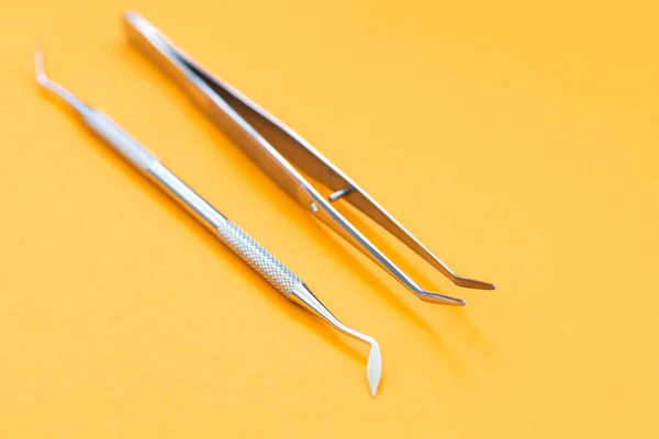 Professional Dentist tools in dental office: dentist mirror, forceps curved, explorer curved, dental explorer angular and explorer curved with chip, right. Dental Hygiene and Health —  Fotos de Stock