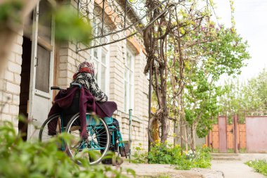 Tekerlekli sandalyedeki yaşlı kadın.