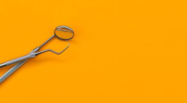 Diş aynası ve turuncu arkaplandaki diğer araçlar