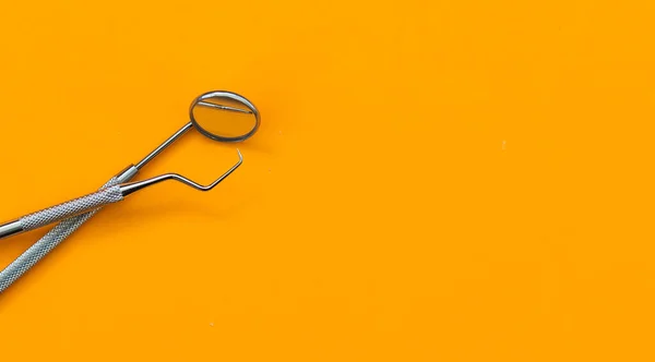 Dental mirror and other tools on orange background —  Fotos de Stock