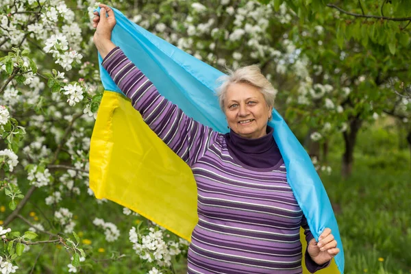 Elderly woman with the flag of ukraine — Stockfoto