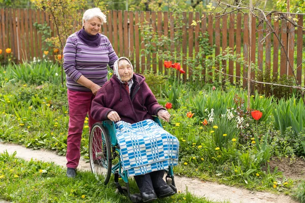 Старший помічник з дуже старої жінки-інваліда в будинку престарілих . — стокове фото