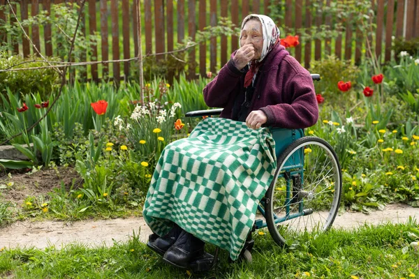 Velha sentada em uma cadeira de rodas parecendo triste e preocupada. depressão, cuidados de saúde e cuidados a idosos — Fotografia de Stock