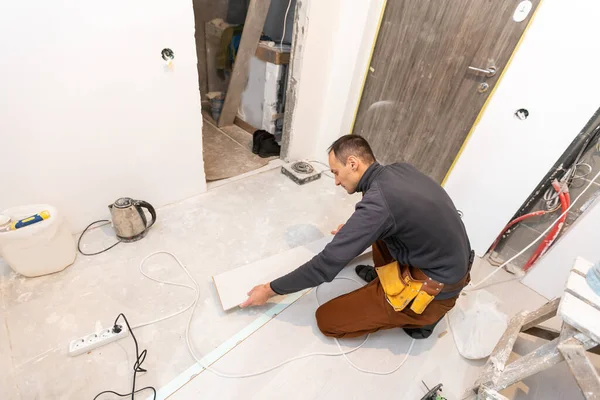 집에 분말 바닥재를 깔고 있는 수리공. — 스톡 사진