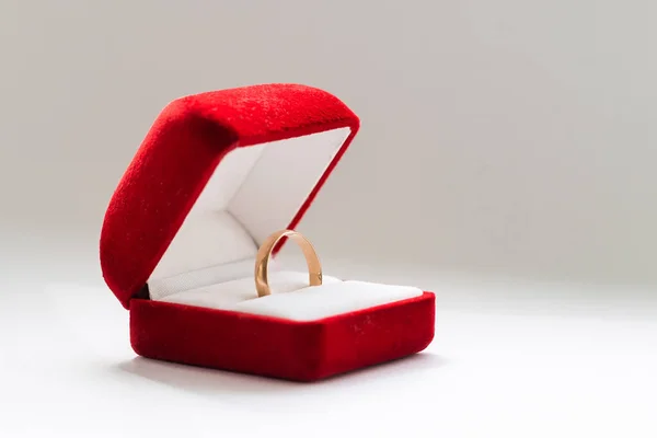 Κόκκινο κουτί για χρυσό δαχτυλίδι σε λευκό φόντο — Φωτογραφία Αρχείου