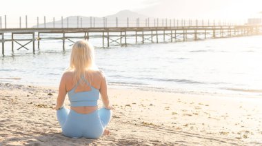 Güneş doğarken sahil üzerinde eğitim genç güzel sportif kız.