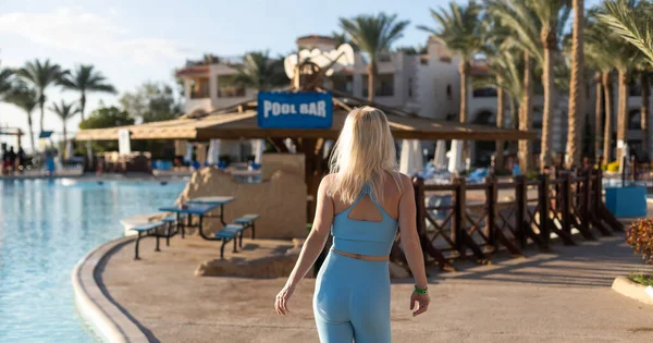 Outdoor shot van fit jonge vrouw in sport beha staan aan het zwembad. — Stockfoto