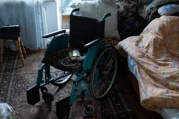 Empty wheelchair in a very poor old house — Fotografia de Stock