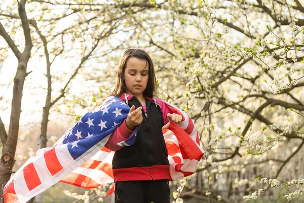 gülümseyen ve dışında Amerikan bayrağı sallayarak mutlu sevimli küçük kız. gülen çocuk 4 Temmuz - Bağımsızlık günü kutlamaları