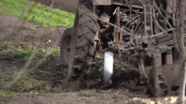 farm tractor with plow plows the field and prepares for sowing.