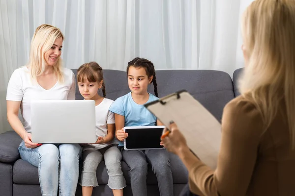 Mão de um psicoterapeuta familiar profissional escrevendo notas na frente de uma família com uma criança durante uma consulta — Fotografia de Stock