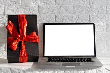 Beyaz ahşap masada boş ekran dizüstü bilgisayar. Noel dekorlu, modern, rahat bir ev oturma odası. Ofis masası çalışma alanı. Kopyalama alanı oluşturun. Kış satışları, online alışveriş.