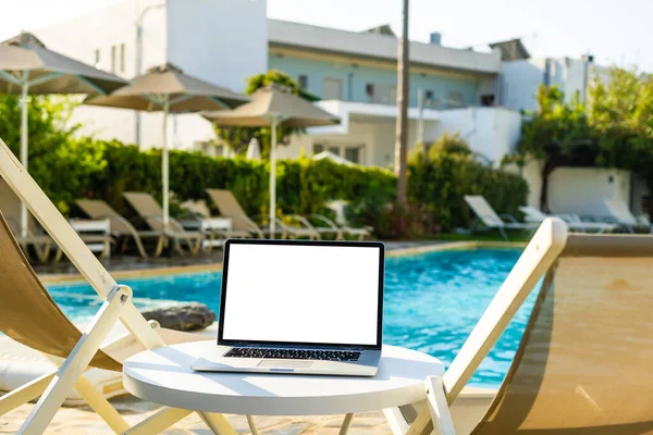 A laptop with an empty screen stands in the courtyard of a beautiful home garden, in Sunny weather. — Stock Photo, Image