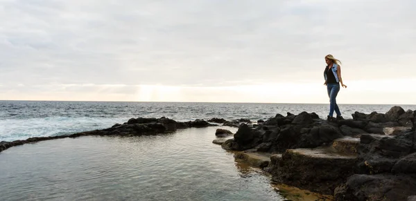 Frauen auf Vulkangestein und blauem Meer mit Wellen, weißem Schaum und Vulkangestein. Kanarische Inseln. Die herrliche Küste des Atlantiks — Stockfoto