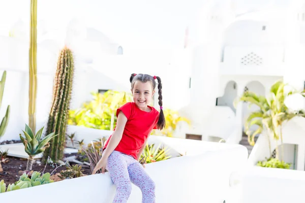Красивая маленькая девочка стоит среди небольшого зеленого листа красивые растения весной и летом в солнечный день. — стоковое фото