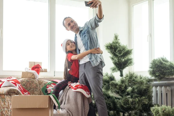 Pai feliz com a filha configurar sua árvore de natal na sala de estar em casa — Fotografia de Stock