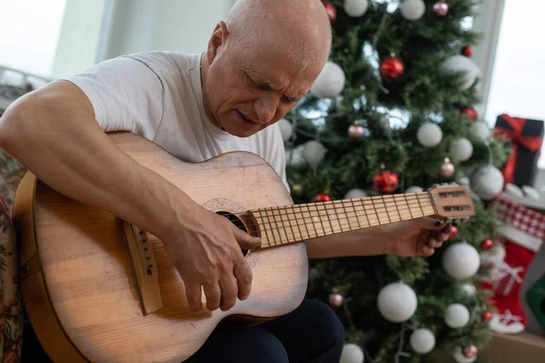 Old man with a guitar at christmas — Stock Photo, Image
