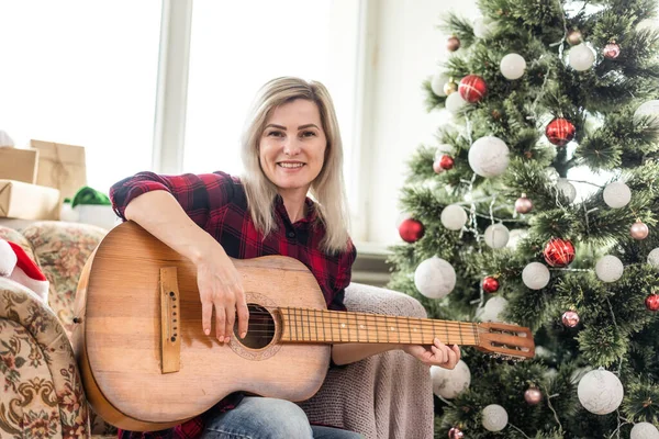 Young woman playing guitar on Christmas holidays. Hygge concept. musician, hobby, lifestyle — Stock Photo, Image