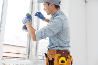 İşçi eve pencere kurup kontrol ediyor.