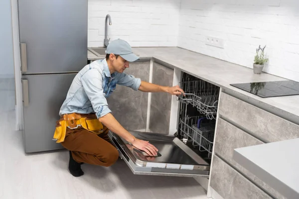 Bulaşık Makinesinin Kurulumu Genç Servis Elemanı Yeni Şık Mutfağa Bulaşık — Stok fotoğraf