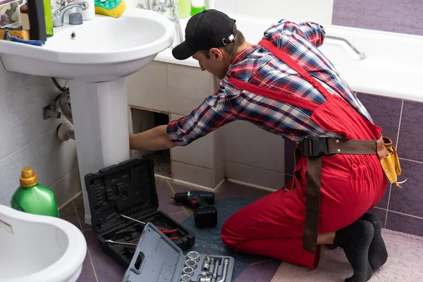 plumber at work in a bathroom, plumbing repair service, assemble and install concept