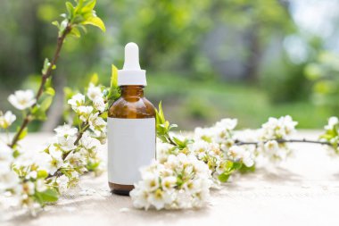 Beyaz arka planda kiraz çiçekleri olan zarif kozmetik kavanozu. Yan görünüm.