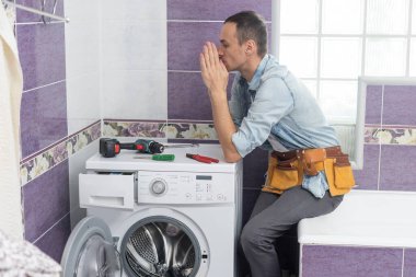 Adam çamaşır makinesini tamir ediyor..