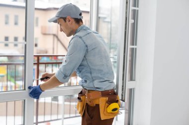 İşçi eve pencere kurup kontrol ediyor.