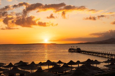 Tahta iskelede altın deniz gün batımı.