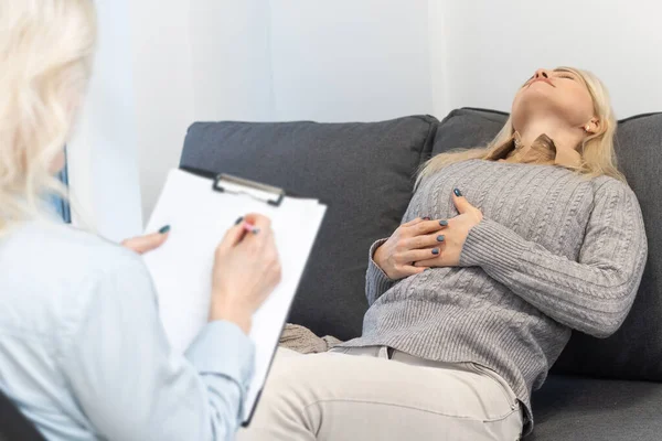 Psikolog, ofisteki zihinsel terapi seansında depresyondaki bir kadını teselli ediyor..