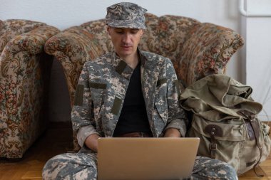 Askeri üniformalı asker istihbarat merkezinde yüksek teknoloji bilgisayar kullanıyor. Dizüstü bilgisayara odaklan.