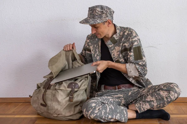 Askeri bilgisayar kullanan sırt çantalı meşgul bir asker..