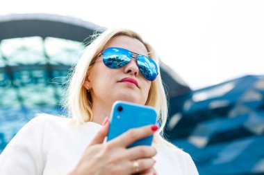 Şehirde yürürken cep telefonu uygulamasında başarılı bir seyahat blogcusu e- posta kutusunu kontrol ediyor. Şık giyinen hoş bir kadın. İnternette arkadaşlarıyla wifi bağlantısı olan akıllı bir telefonla sohbet ediyor..