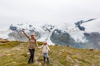 Anne ve çocuklara dağların eteklerinde yürüyüşe çıkmalarına..
