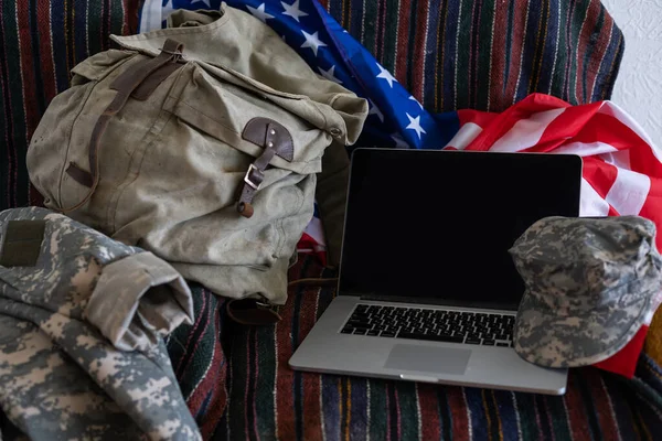 backpack and laptop against American flag. Military education.