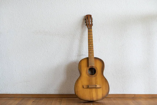 Klassieke Gitaar Liggend Voor Een Muur Als Achtergrond — Stockfoto