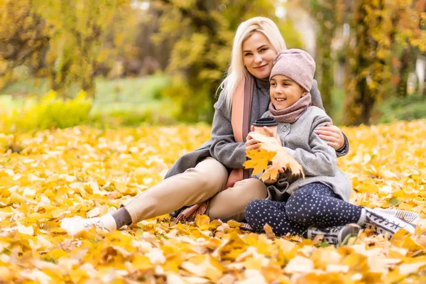 母亲和女儿之间飘落的树叶秋天公园里有乐趣 — 图库照片