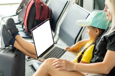 mother and daughter with laptop with blank screen.