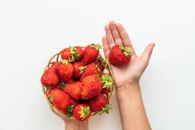 Bulanık yeşil arka planda, elinde ev yapımı çilek olan bir tabak. Kapat.