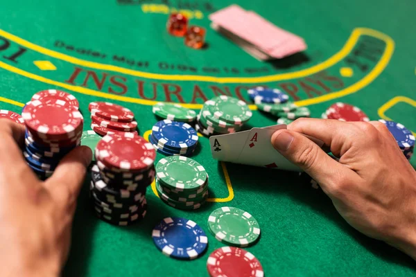 man playing blackjack at the table and betting chips.