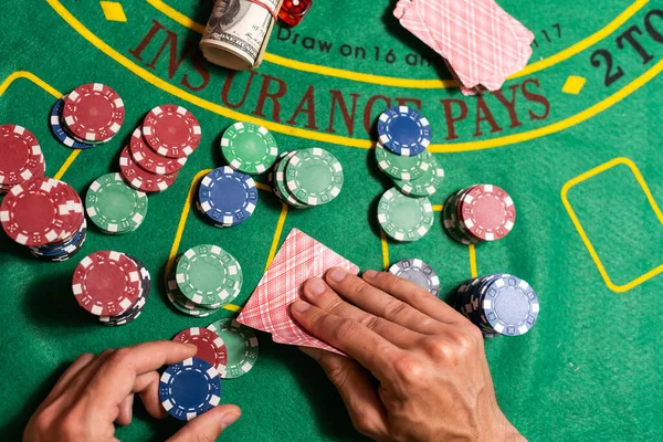 man playing blackjack at the table and betting chips.