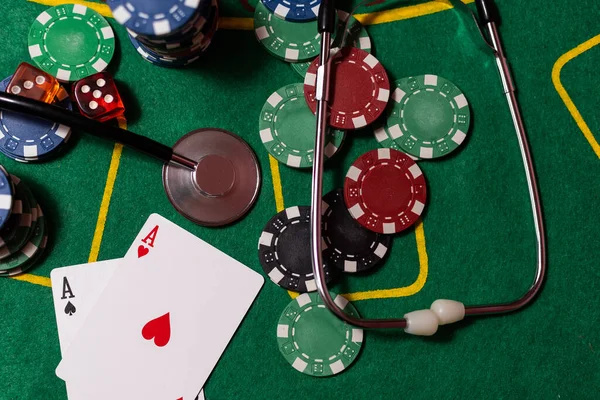 poker chips, money, stethoscope on blackjack table