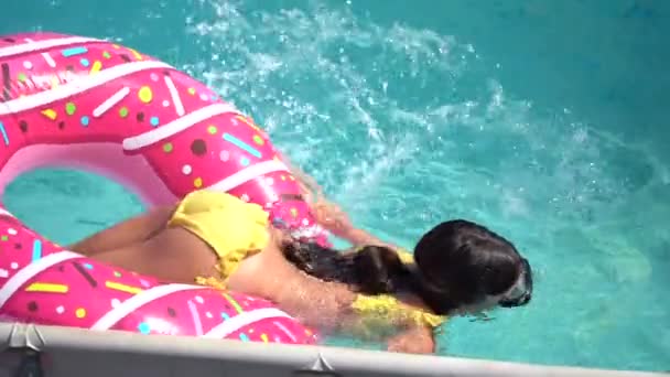 女孩在花园里的游泳池里打一个充气圈 — 图库视频影像
